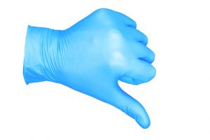 a photo of isolated hand wearing cleaning medical glove thumb down / hand in the position of thumbs down because of unclean hospital lack in medical facility cleaning